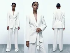 Mujer posa con un elegante traje blanco de pantalón y blazer con cinturón. Un look sofisticado para combinar traje blanco mujer.