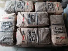 Sztaplowane worki z betonem B25, każdy po 25 kg. Wiedząc, ile waży kubik betonu, można oszacować potrzebną ilość materiału.