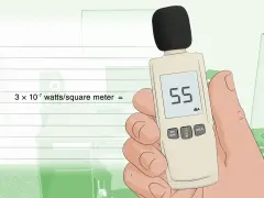 Main tenant une main un sonomètre affichant 55 dBA, prêt à effectuer une decibels mesure.