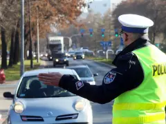 Policjant kieruje ruchem na ulicy. Kierowca zatrzymuje się, bo zgubił prawo jazdy i boi się kontroli.