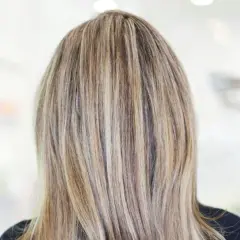 En frisyr med brunt hår med kalla slingor som ger en naturlig och modern look.