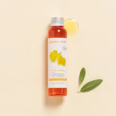 Flacon d'huile d'onagre Aroma-Zone, aux multiples bienfaits pour la peau et les cheveux. Une goutte d'huile dorée et deux feuilles vertes complètent la scène.