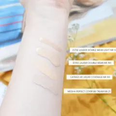 Smugi podkładów na przedramieniu: Estee Lauder, Catrice i Missha.