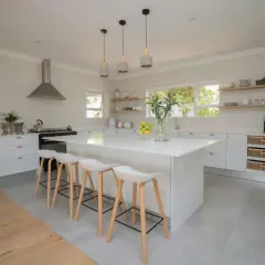 Une cuisine moderne et lumineuse, parfaite pour **créer sa cuisine** de rêve. Îlot central blanc, tabourets design, et rangements astucieux.
