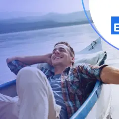 Uśmiechnięty mężczyzna odpoczywa w łodzi, czując spokój i relaks. Takie chwile są możliwe dzięki wsparciu Santander Select.