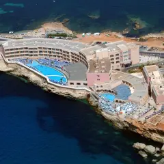 Widok z lotu ptaka na Paradise Bay Resort z basenami i leżakami, położony na klifie nad turkusowym morzem.