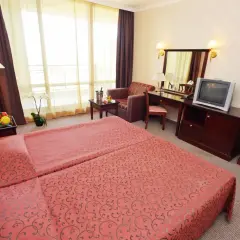 Pokój hotelowy z dwoma łóżkami, owocami, kwiatem i telewizorem. Jakbyś był **gladiola star** w tym miejscu.