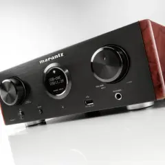 Elegancki wzmacniacz Marantz HD AMP1 z drewnianymi panelami bocznymi, wyświetlaczem USB-DAC i pokrętłami.