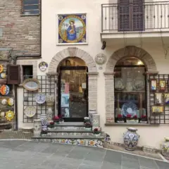 Deruta cosa vedere: bottega di ceramiche con soli, lune, vasi e decorazioni murali.