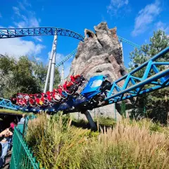 Kolejka Blue Fire w Europa Park Niemcy pędzi po niebieskich torach obok skalistej góry.