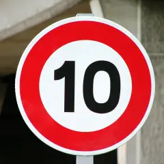 Panneau rond rouge et blanc indiquant la vitesse maximale autorisée de 10 km/h.