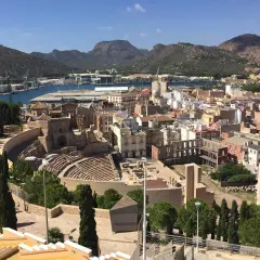 Vista panorámica de Cartagena, con el teatro romano y el castillo de la Concepción dominando el paisaje urbano y el puerto.