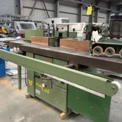 Une toupie tenonneuse verte, machine à bois industrielle, prête pour des travaux de menuiserie précis.