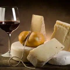 Un verre de vin rouge et une sélection de fromages, un accord parfait pour savoir quel vin avec le fromage.