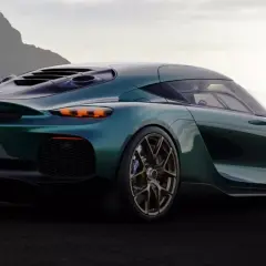 Zielony Koenigsegg Gemera, auto z największą mocą, prezentuje swoje sportowe linie na tle górskiego krajobrazu.