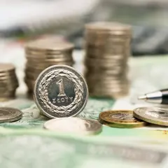 Stos monet i banknotów, pióro. Zastanawiasz się, jakie obligacje warto kupić, by pomnożyć swój kapitał?