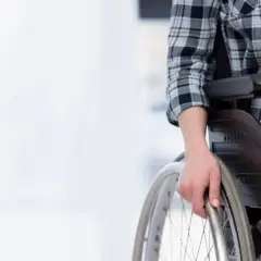 Osoba na wózku inwalidzkim, przygotowująca się do samodzielnego poruszania, symbolizuje nadzieję na godne życie i wsparcie, jakim jest emerytura socjalna.
