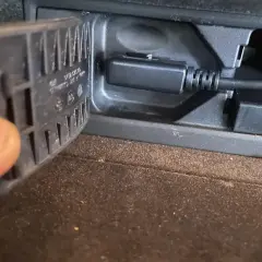 Kabel AUX podłączony do gniazda, gdy **bluetooth przerywa**. Palec przytrzymuje klapkę.