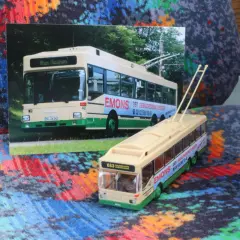 Ein Modell eines Obusses steht neben einer Fotografie eines echten Obusses. Beide zeigen die Aufschrift "EMONS DER GEBÄUDEDIENSTLEISTER".