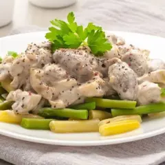 Serca drobiowe w sosie śmietanowym z pieprzem, podane z zieloną fasolką i żółtym szparagiem. Idealne danie, gdy zastanawiasz się, ile gotuje się serca drobiowe.