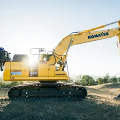 Żółta koparka Komatsu PC 240 LC na wzgórzu. Idealna do leasingu maszyn budowlanych.