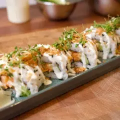 En rad läckra sushirullar med lax och gurka, toppade med majonnäs och krispiga lökar. Ett perfekt sushi recept för hemmakockar.