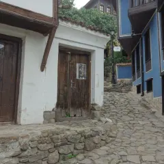 Kamienna uliczka w Plovdiv Bułgaria, z tradycyjnymi domami o białych i niebieskich fasadach.
