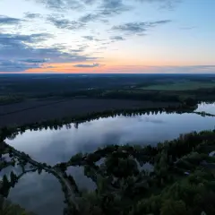Zachód słońca nad malowniczymi jarosławkami, gdzie spokojne wody odbijają niebo w odcieniach pomarańczy i błękitu.
