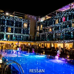 Una festa notturna con luci stroboscopiche su un edificio moderno e una piscina illuminata. Sembra un luogo ideale per locali scambisti a Ibiza.