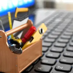 Narzędzia na klawiaturze laptopa sugerują, jak wejść do BIOS-u i dokonać napraw.