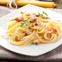 Prawdziwa carbonara bez śmietany, zgodnie z włoską tradycją. Makaron tagliatelle z guanciale, jajkami i parmezanem.