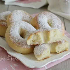 Ciambelle al forno soffici e profumate, cosparse di zucchero a velo. Una delizia per la colazione o la merenda.