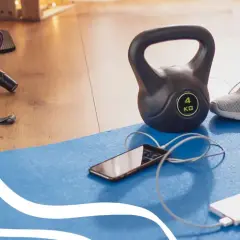 Gotowy sprzęt do treningu: hantle, gumy, rolka, mata, telefon i powerbank. Idealne warunki do cardio w domu.