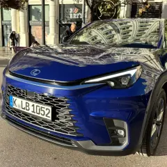 Niebieski Lexus LBX na ulicy. Zbliżenie na przód auta, widoczna krata wlotu powietrza i reflektory. Wymiary tego kompaktowego SUV-a są idealne do miasta.