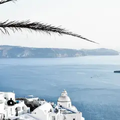 Santorini, Grecja. Białe domy na klifie, błękitne morze i wyspy w oddali. Ciekawe miejsca i widoki.