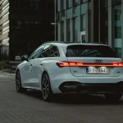 Białe Audi A5 Avant 2025 z nowoczesnymi światłami LED na tle miejskiej architektury.