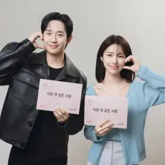 Jung Hae In und seine Kollegin halten Drehbücher für "A Love So Beautiful" und lächeln.