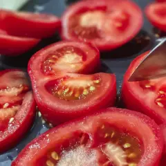 Pokrojone pomidory na desce. Potas na co pomaga? Wpływa na ciśnienie i pracę serca, a pomidory są jego dobrym źródłem.
