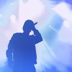 Silhouette di un rapper con microfono, luci blu e bianche sullo sfondo. Le origini di Tony Boy.