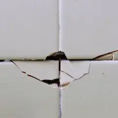 Dettaglio di piastrelle scheggiate, un problema comune per chi cerca come riparare piastrelle scheggiate.