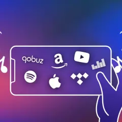 Une main tient un smartphone affichant plusieurs logos d'application musicale : Qobuz, Amazon Music, YouTube Music, Spotify, Apple Music et Tidal.
