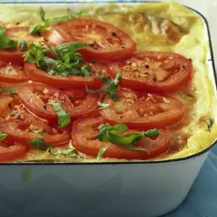 Herzhafte auberginen lasagne, überbacken mit Tomatenscheiben und frischem Basilikum, duftet verführerisch.