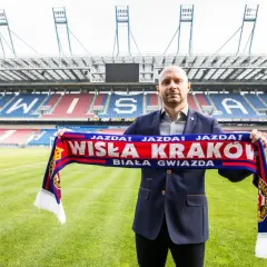 Artur Skowronek z szalikiem Wisły Kraków na tle stadionu. "Jazda! Wisła Kraków! Biała Gwiazda!" - krzyczy kibic.