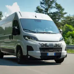 Un fourgon Fiat Ducato 2.3 Multijet 140 Euro 6 roule sur une route bordée d'arbres.