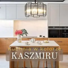 Elegancka kuchnia w kolorze kaszmiru z drewnianymi frontami i marmurowym tłem. Na wyspie bukiet kwiatów i zastawa.