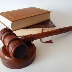 Młotek sędziowski i księgi symbolizują zdolność sądową a procesową.