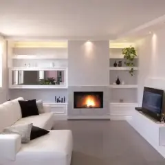 Soggiorno moderno con camino e TV, con una parete attrezzata in cartongesso che integra librerie e vani contenitori.