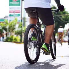 Rowerzysta w jaskrawozielonych butach jedzie ulicą. W tle widać stację benzynową. Dowiedz się, jak ustawić licznik rowerowy, by śledzić swoje trasy.