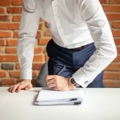 Mężczyzna w białej koszuli podpisuje dokumenty. Co jeśli ZUS nie przyznał świadczenia rehabilitacyjnego?