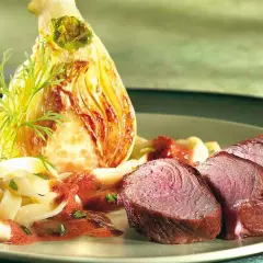Tranches de rumsteak d'agneau rosé, accompagnées de pâtes fraîches, d'une sauce rouge et d'un fenouil braisé.